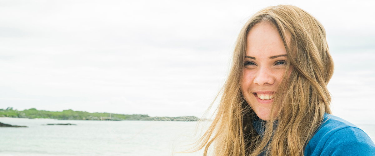En ung jente poserer på stranden